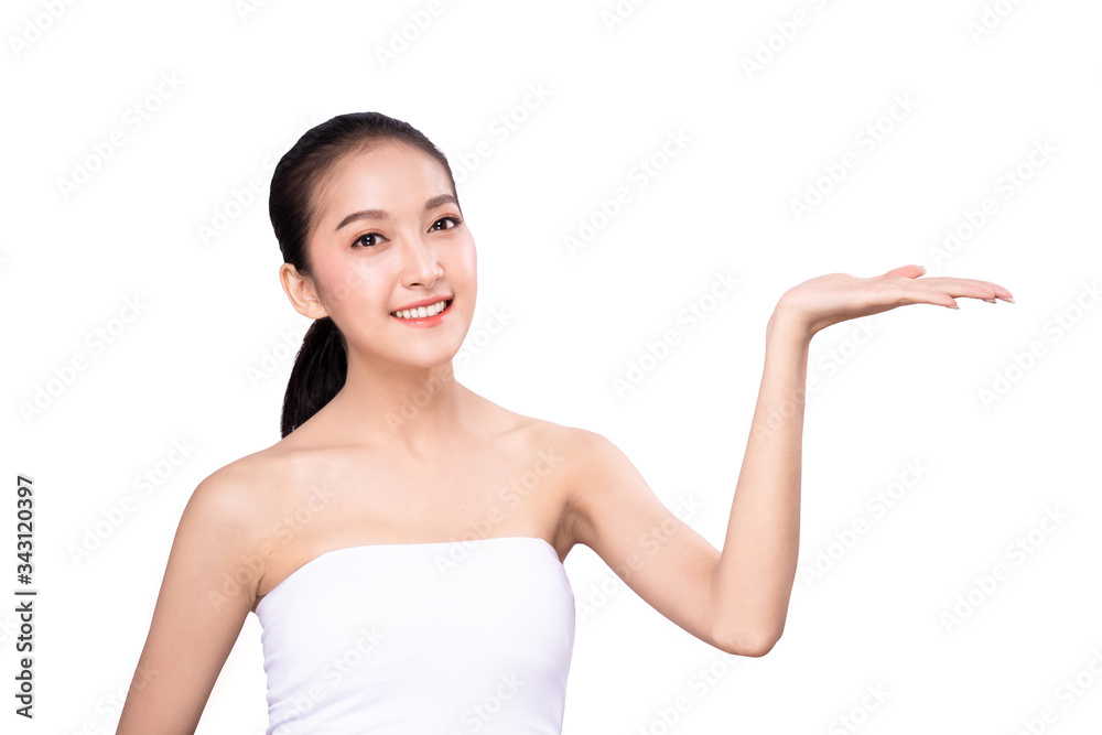 Portrait of Asian beautiful young woman pointing one hand with finger on upper side with smile face. The girl standing and looking at camera in studio for beauty advertisement and presentation. Portrait of Asian beautiful young woman pointing one hand with finger on upper side with smile face. The girl standing and looking at camera in studio for beauty advertisement and presentation.