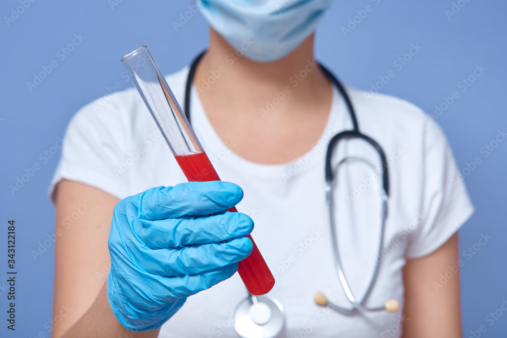 Horizontal indoor picture of unknown virologist holding test tube with blood of infected patient with covid19, wearing uniform, working in laboratory, result processing. Coronavirus outbreak concept. Horizontal indoor picture of unknown virologist holding test tube with blood of infected patient with covid19, wearing uniform, working in laboratory, result processing. Coronavirus outbreak concept.