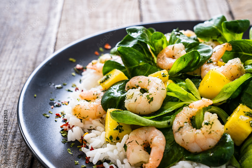 Prawns with rice and vegetables on wooden table
Prawns with rice and vegetables on wooden table