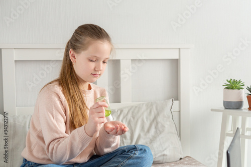 Girl applying an antibacterial antiseptic hand gel for hands disinfection and cleaning