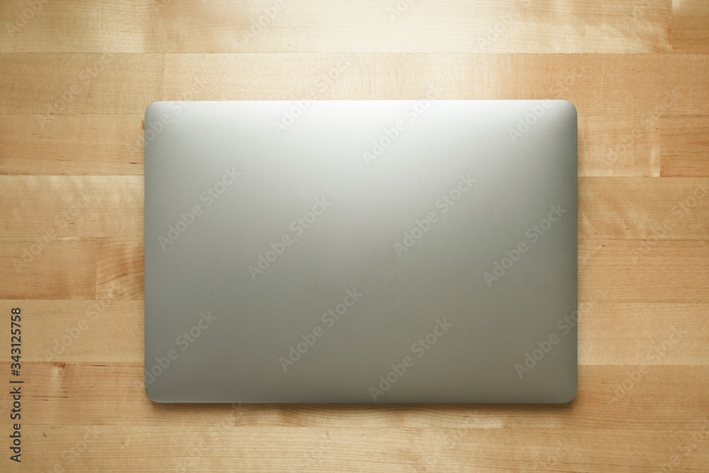 Top view of simple laptop on wooden desk in warm room light. Top view of simple laptop on wooden desk in warm room light.