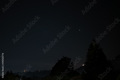 starlink satellites of elon musk's spacex project that travel the sky passing under venus, satellites to transmit the internet, broadband, global connection