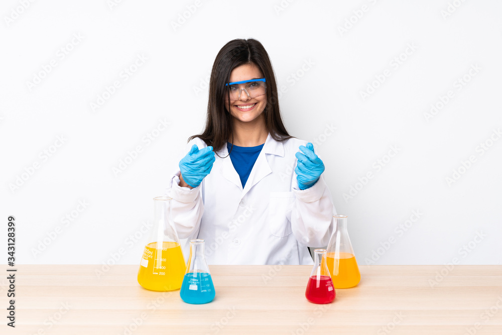 Young scientific woman in a table making money gesture Young scientific woman in a table making money gesture
