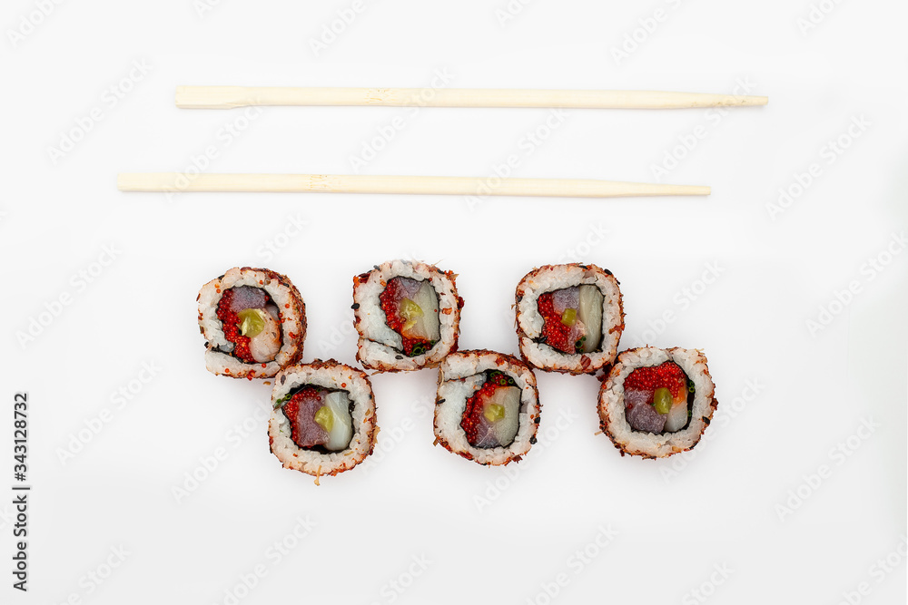 Japanese cuisine. Maki sushi. isolated on white background. Sushi rolls lie on a white background, top view, next to them are Japanese bamboo sticks. Concept idea for a japanese restaurant menu.