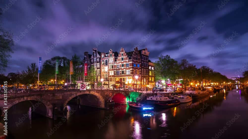 Amsterdam amazing timelapse of the corner of 'Prinsengracht' and 'Brouwersgracht' canals after sunset and blue hour at night in summer. With fast moving clouds and stars. UNESCO World Heritage list