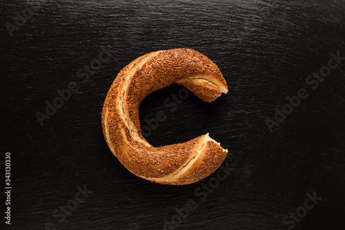 Turkish bagel bite on black background (simit)