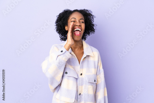 Young African American woman isolated on purple background shouting with mouth wide open