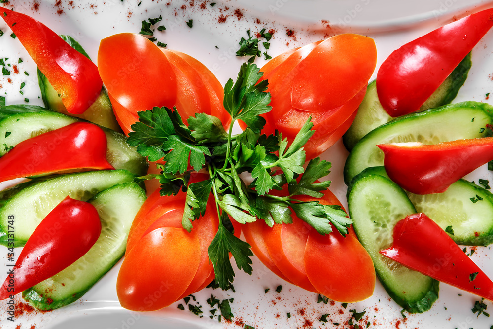 Sliced tomatoes, cucumbers and parsley on a plate sprinkled with spices