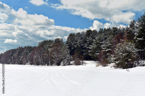 winter landscape. frozen river, forest, blue sky