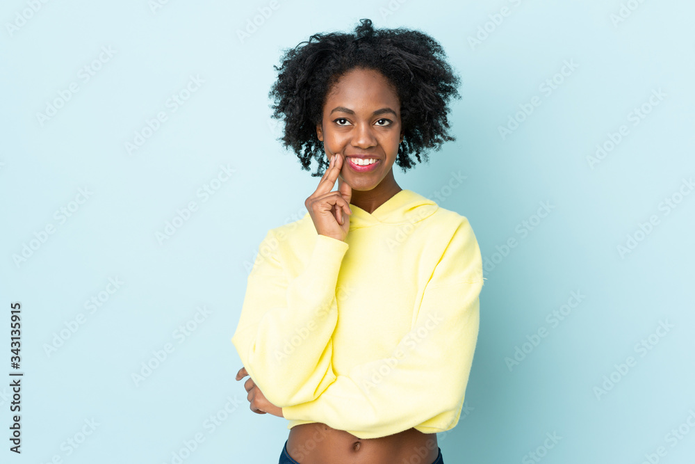 Young African American woman isolated on blue background thinking an idea while looking up Young African American woman isolated on blue background thinking an idea while looking up