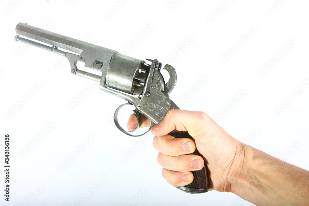 XIX century old rare muzzle loading percussion cap revolver pistol in hand isolated on white background XIX century old rare muzzle loading percussion cap revolver pistol in hand isolated on white background