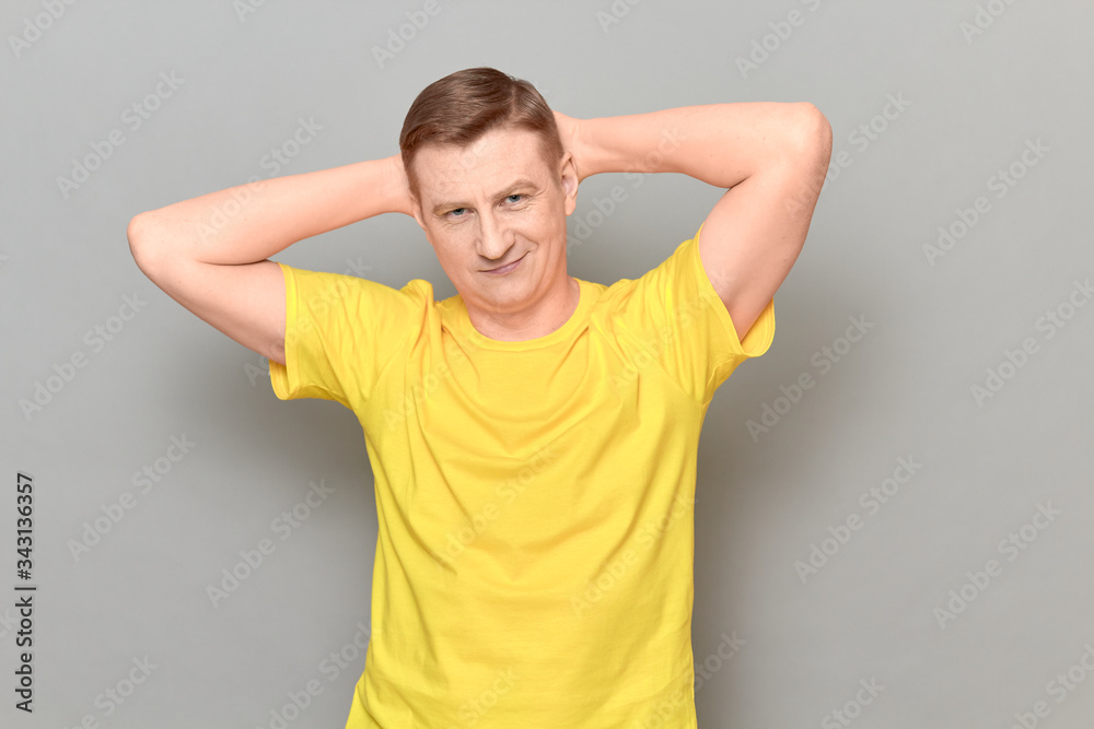 Portrait of happy mature man holding hands behind head and smiling Portrait of happy mature man holding hands behind head and smiling