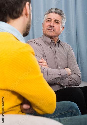 фотографія Adult father and son solve problems