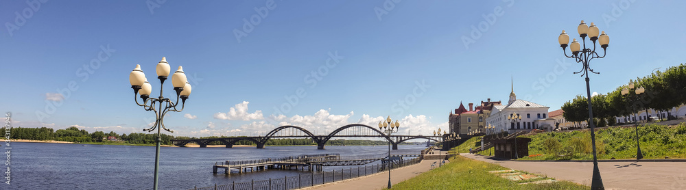 Obraz premium Rybinsk. View of the building of the grain exchange, the Holy Transfiguration Cathedral and the bridge over the Volga river. View from the river