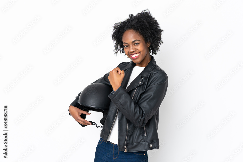 Young African American woman with a motorcycle helmet isolated on white background celebrating a victory Young African American woman with a motorcycle helmet isolated on white background celebrating a victory