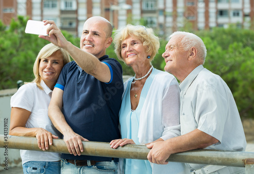 Mature people standing in the garden and taking selfie