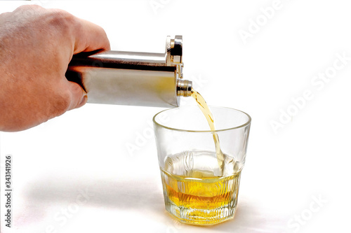 pour from a jar into a glass tumbler isolated on a white
