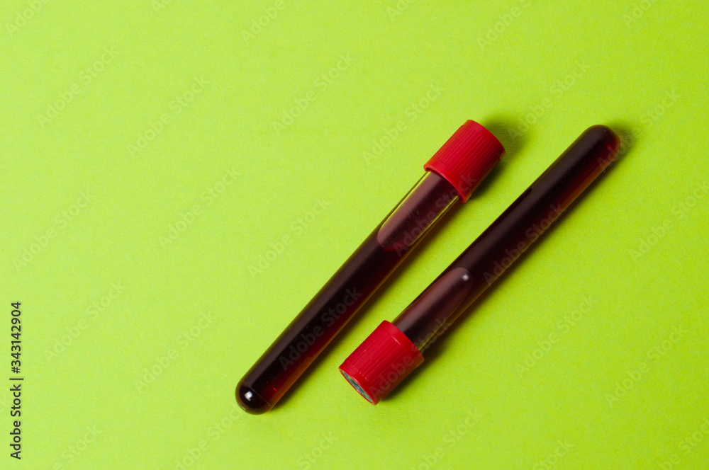 Two test tubes with blood isolate on green background. Concept medicine, the fight against viruses and bacteria, diseases Two test tubes with blood isolate on green background. Concept medicine, the fight against viruses and bacteria, diseases