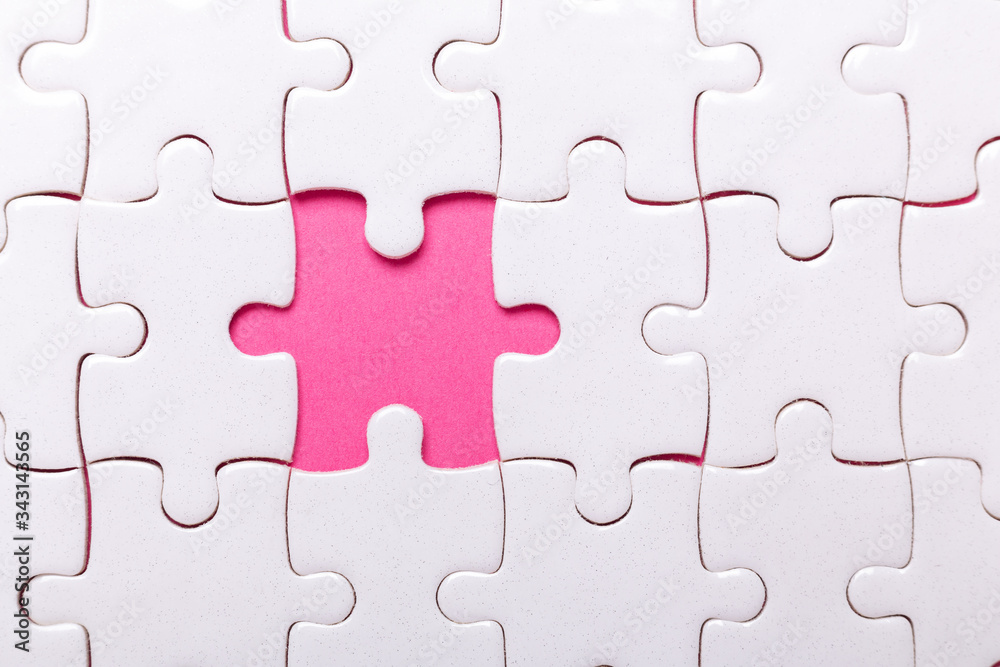 White puzzle background with one piece missing. Close-up. Concept success of business White puzzle background with one piece missing. Close-up. Concept success of business