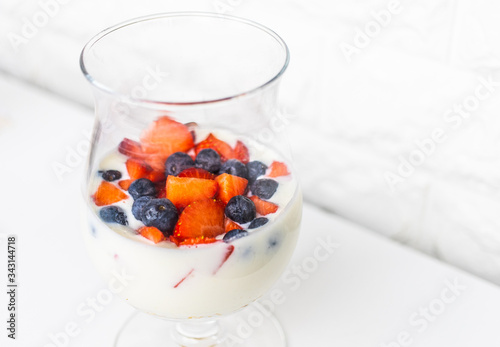 Delicious and natural glass with yogurt, oatmeal, strawberries, blueberries and milk all mixed ready to drink