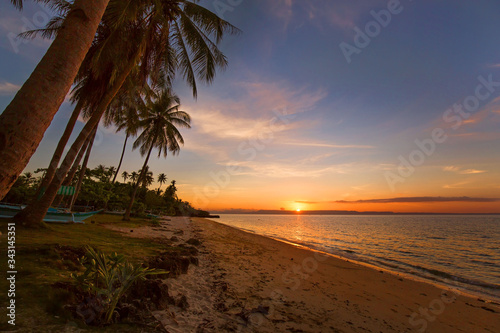  sun on horizon and sunset reflection in sea water, a outrigger at the beach a topical scene