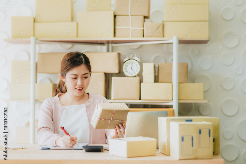 Young Asian women entrepreneur business owner work at home preparing to delivery goods in parcel to online customer Young Asian women entrepreneur business owner work at home preparing to delivery goods in parcel to online customer