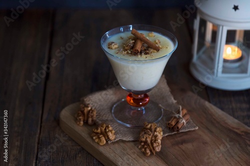 rice pudding on wooden background with candle and walnut