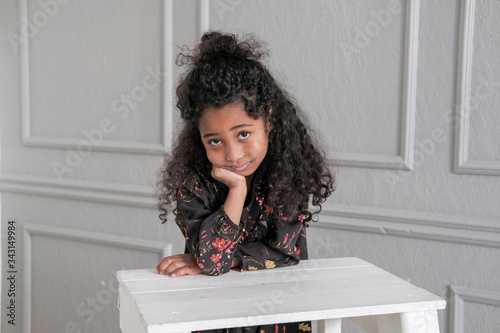 The African American child looks directly into the camera in the children's room.