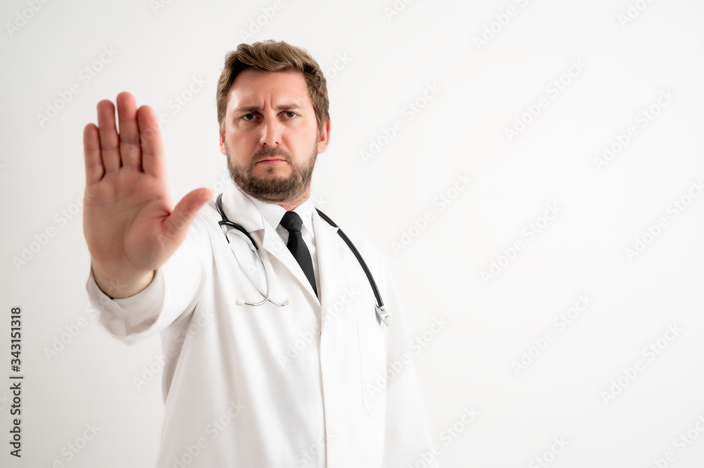 Male doctor with stethoscope in medical uniform showing stop sign Male doctor with stethoscope in medical uniform showing stop sign