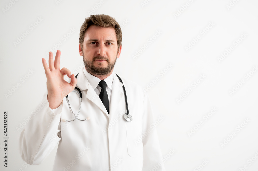 Male doctor with stethoscope in medical uniform showing OK sign Male doctor with stethoscope in medical uniform showing OK sign