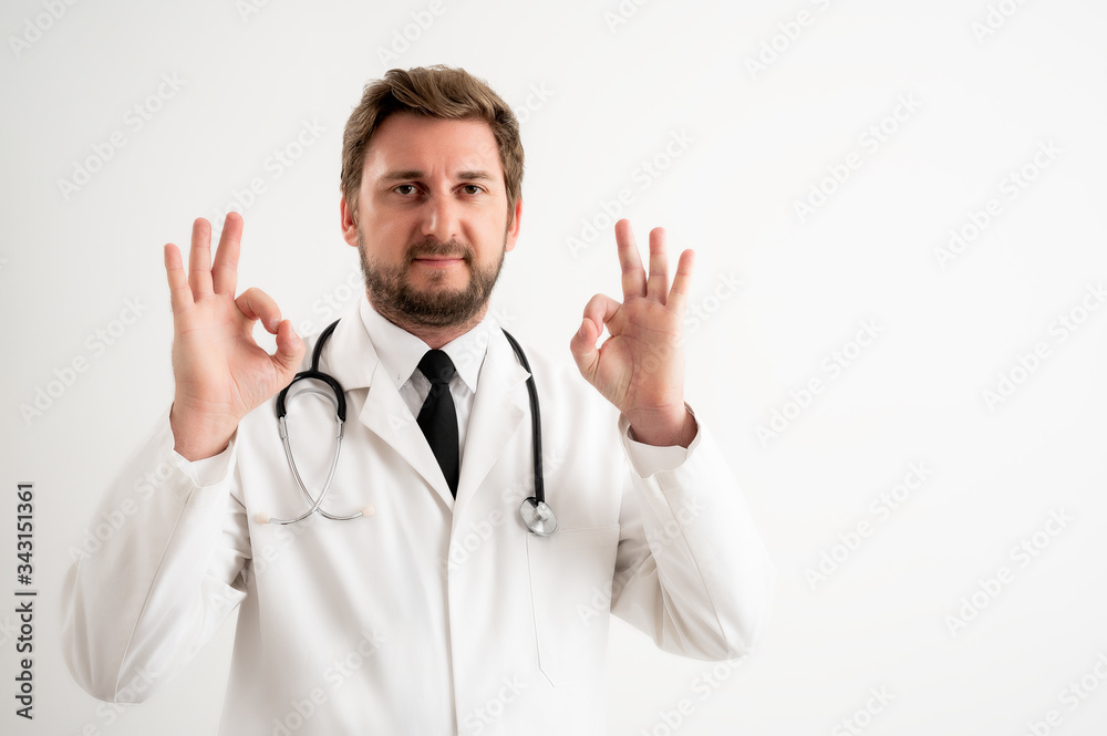 Male doctor with stethoscope in medical uniform showing double OK sign Male doctor with stethoscope in medical uniform showing double OK sign