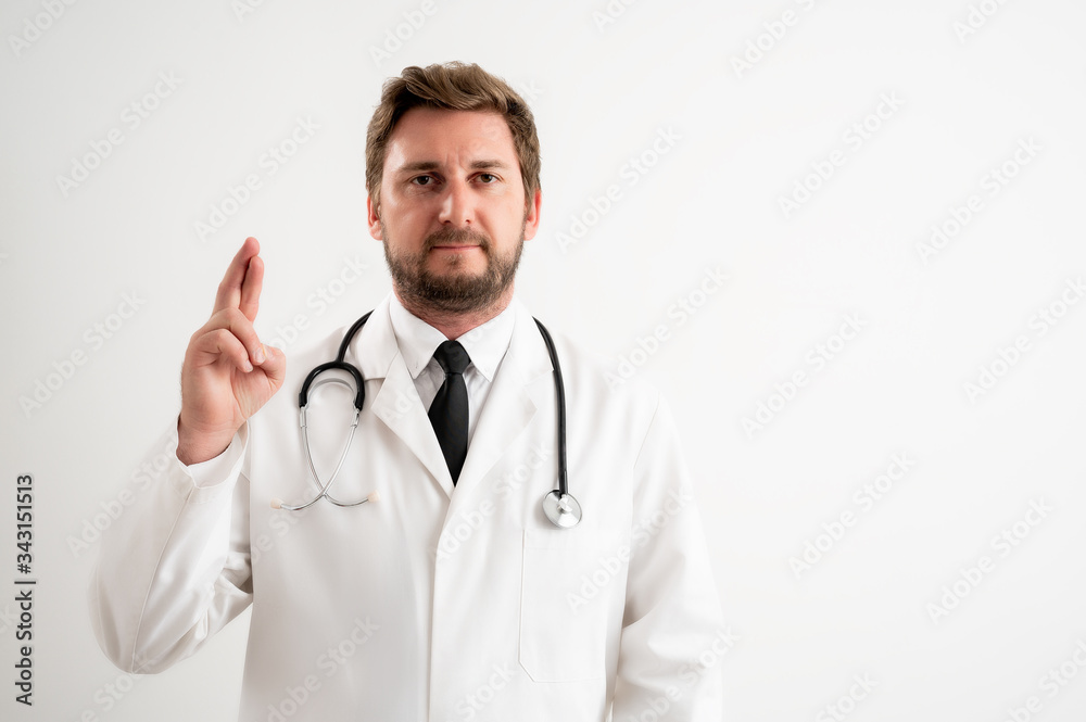 Male doctor with stethoscope in medical uniform showing good luck
