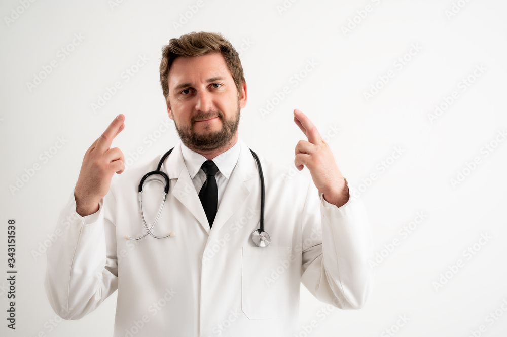 Male doctor with stethoscope in medical uniform showing double good luck Male doctor with stethoscope in medical uniform showing double good luck