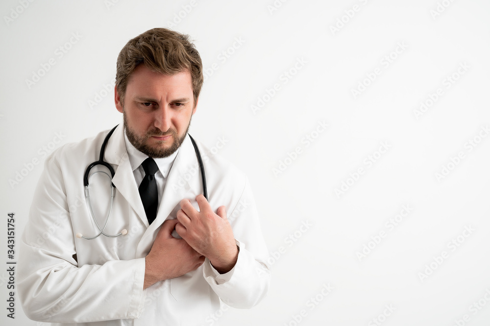 Male doctor with stethoscope in medical uniform suffering heart ache or breast pain, cardiac problems Male doctor with stethoscope in medical uniform suffering heart ache or breast pain, cardiac problems