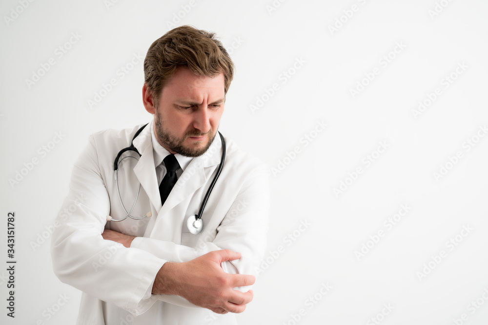 Male doctor with stethoscope in medical uniform has elbow pain Male doctor with stethoscope in medical uniform has elbow pain