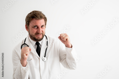Male doctor with stethoscope in medical uniform raised fists up exclaiming with joy and excitement © Cipri Suciu 