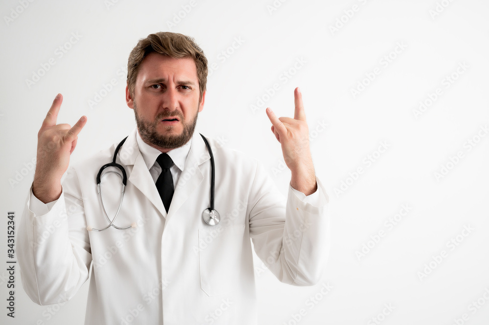 Male doctor with stethoscope in medical uniform doing rock symbol with hands up Male doctor with stethoscope in medical uniform doing rock symbol with hands up