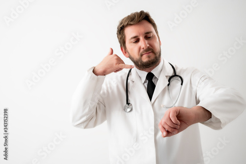 Male doctor with stethoscope in medical uniform showing call me gesture