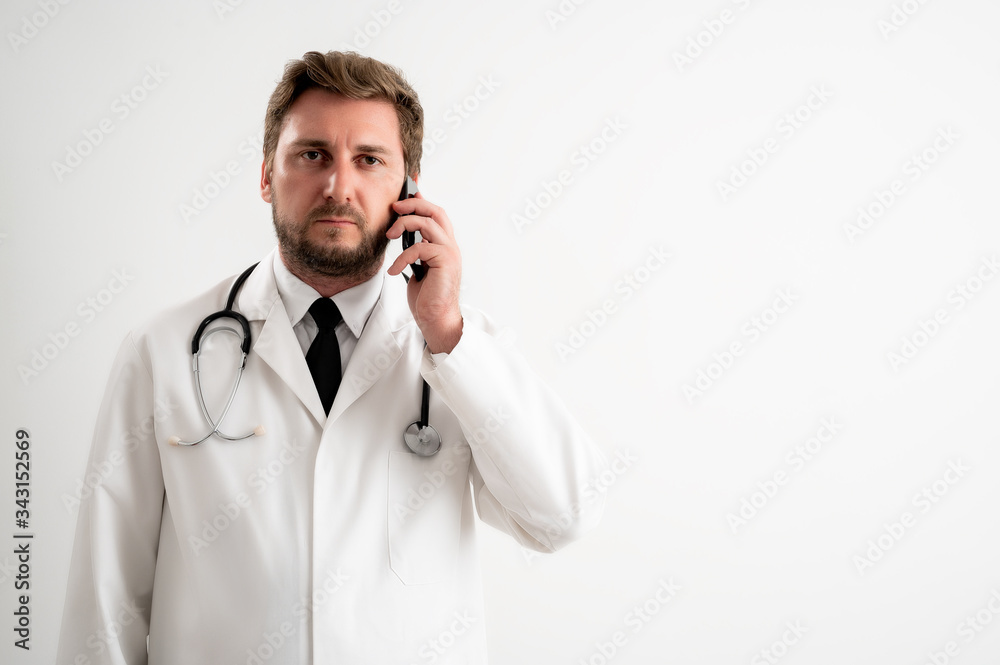 Male doctor with stethoscope in medical uniform talking on cellphone Male doctor with stethoscope in medical uniform talking on cellphone
