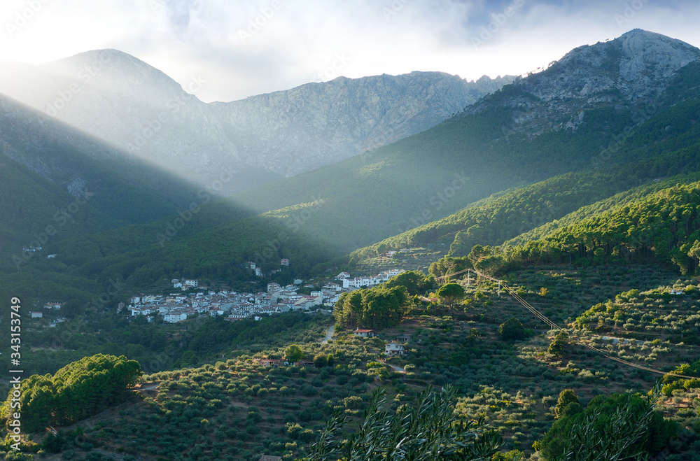 Fototapeta premium Rayos de sol sobre la localidad abulense de Guisando, en el valle del Tiétar en pleno Parque Regional de la Sierra de Gredos. Destaca las cimas del Cabezo del Cervunal, La Mira y la Cabeza del Covacho
