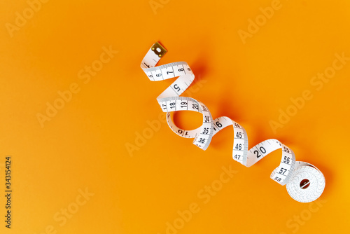 Orange background with centimeter. Diet and healthe care concept. Copy space. Place for text and design.