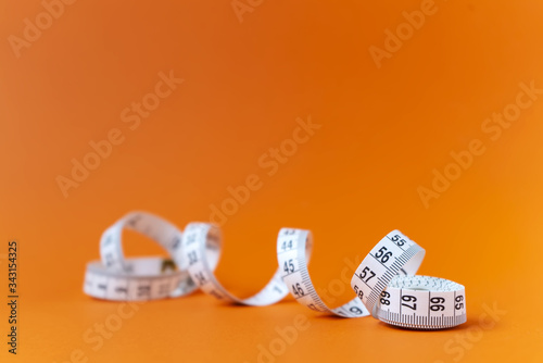 Orange background with centimeter. Diet and healthe care concept. Copy space. Place for text and design. photo