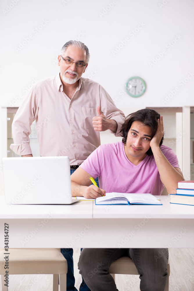 Old father helping his son in exam preparation Old father helping his son in exam preparation