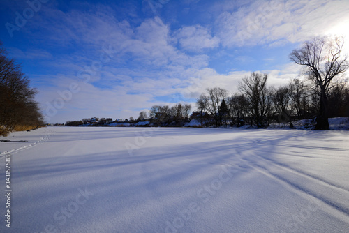 A general plan of a view of a snowy lake with long shadows from the trees. © Вячеслав Бондарев