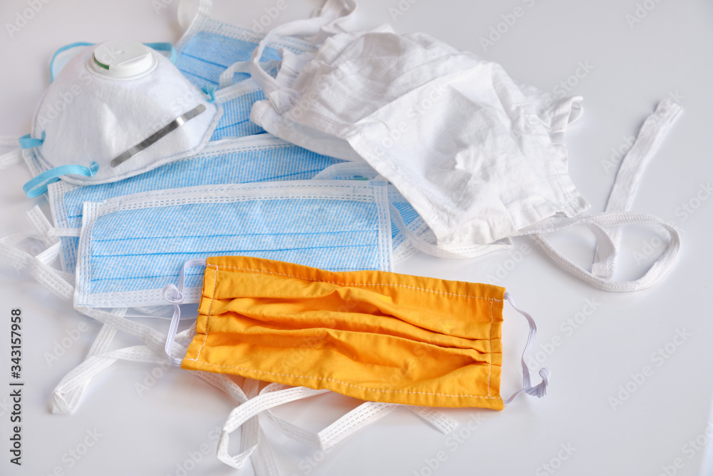 a-stack-of-different-types-of-face-masks-lying-on-a-heap-on-white