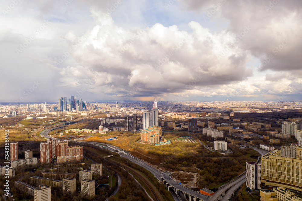 panoramic view with skyscrapers and motorways of a big city at sunset shot from a drone