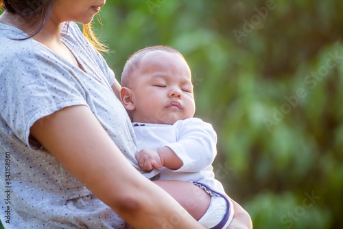 Asian mother whacked caring and holding her newborn is sleeping, Asian newborn baby with a baby rash