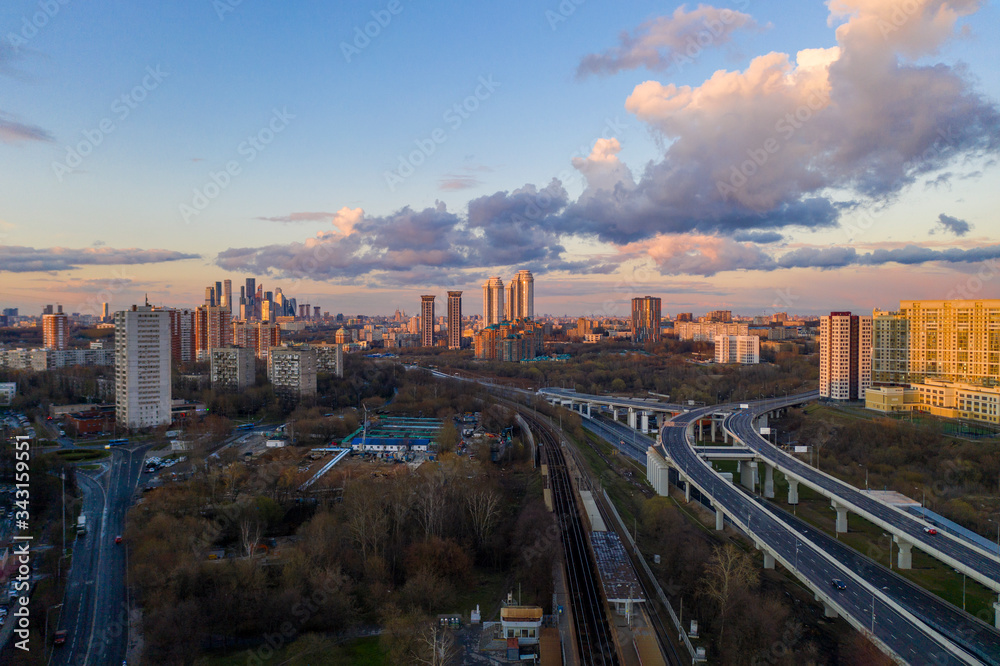 panoramic view with skyscrapers and motorways of a big city at sunset shot from a drone