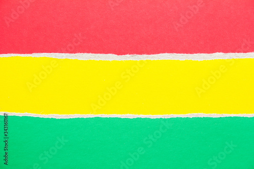 Red  yellow and green torn sheet of cardboard paper texture background. Copy space for text message.