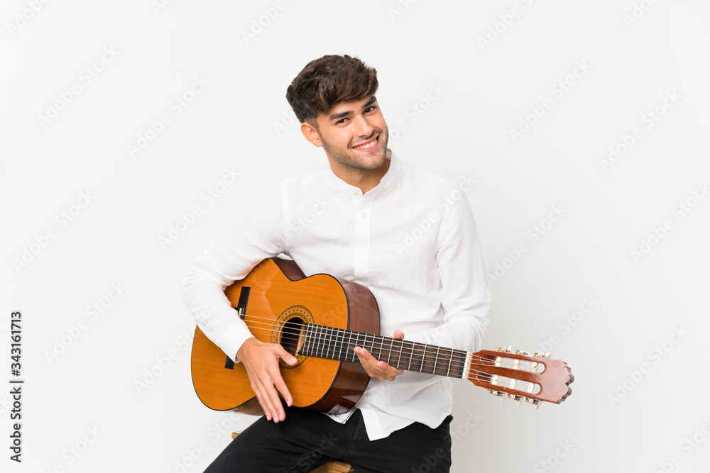 Young handsome man with guitar over isolated white background